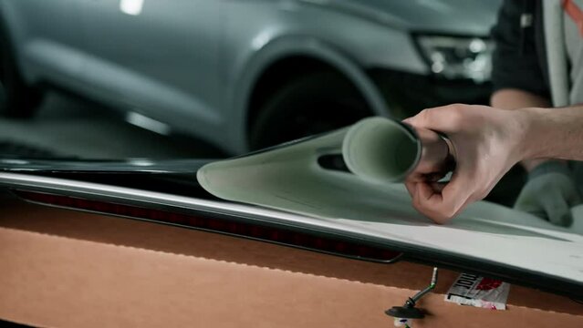 Gluing the film on the spoiler to protect the paint which protects the paint from scratches and stones auto detailing