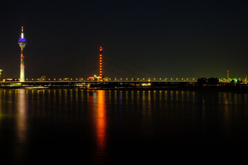 Obraz premium TV tower reflecting on Rhine River at night in Duesseldorf, Germany