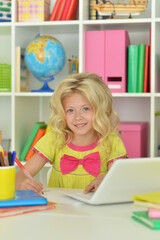 girl using laptop at desk at home