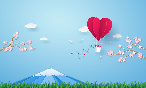 Origami hot air balloon heart flying on the sky over the grass with Fuji mountain and cherry blossom.
Vector illustrator design in paper art concept.