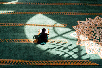 A Muslim woman praying inside the mosque.