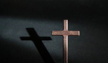 Crucifix wooden cross isolated on dark background. Copy space.