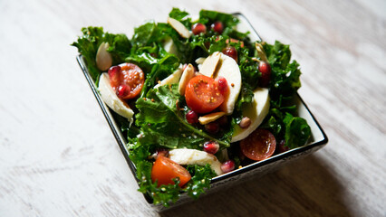 Delicious and healthy kale salad, mozzarella cheese and cherry tomatoes.