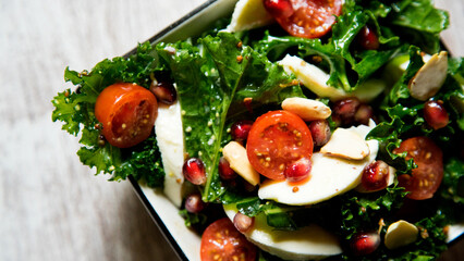 Delicious and healthy kale salad, mozzarella cheese and cherry tomatoes.
