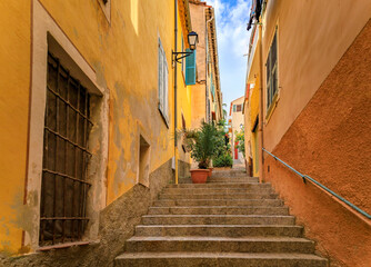 Fototapeta na wymiar Stairs on a narrow street in the Old Town of Villefranche sur Mer, France
