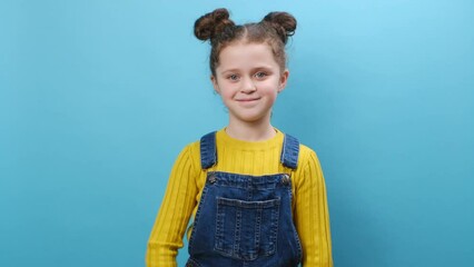 Portrait of secret little girl saying hush be quiet with finger on lips shhh gesture close her mouth lock and throw away key, posing isolated over blue background studio. Childhood lifestyle concept