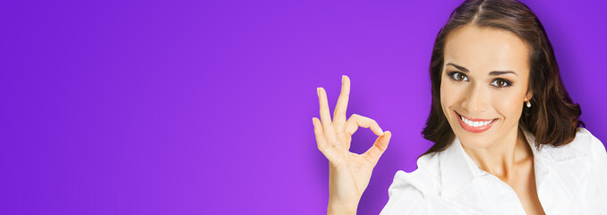 Businesswoman in confident cloth showing ok okay hand sign gesture, over blurred modern office...