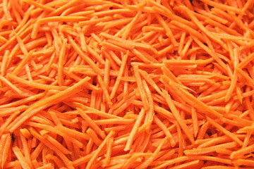 Grated Carrots Background is Spinning. Fresh Juicy Chopped Carrots. Food Orange Color Backdrop. Shredded Carrot Abundance is Rotating. Crushed, Cut Vegetables for Soup, Garnish, Salad. Healthy Eating