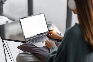Beautiful Asian Woman smile and relaxing at home and using laptop computer sitting on cozy sofa