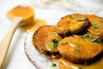 Fried breaded eggplant slices covered with honey.