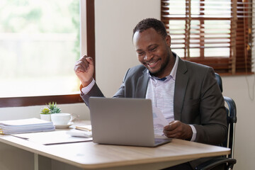 Fototapeta premium Success American African makes financial report and studies annual figures, analyzes profits. Accountant checks status of financial