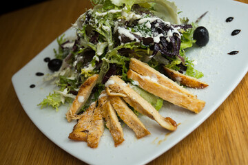A Caesar salad is a salad of romaine lettuce, croutons, and chicken with lemon juice, olive oil, egg, Worcestershire sauce, anchovies, garlic, Dijon mustard, Parmesan cheese, and black pepper.