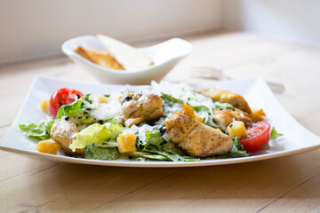 A Caesar salad is a salad of romaine lettuce, croutons, and chicken with lemon juice, olive oil, egg, Worcestershire sauce, anchovies, garlic, Dijon mustard, Parmesan cheese, and black pepper.