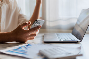 Close up of young man using calculator and laptop for doing financial mathematics on wooden table in office and working background - business, tax, accounting, statistics and analytical research conce