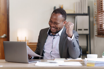 Obraz premium Success American African makes financial report and studies annual figures, analyzes profits. Accountant checks status of financial
