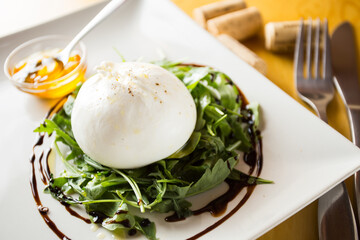 Burrata salad. The burrata is a fresh cow's milk cheese, with spun paste and round in shape, with an external appearance similar to that of mozzarella 