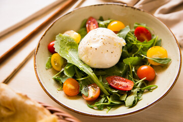 Burrata salad. The burrata is a fresh cow's milk cheese, with spun paste and round in shape, with...