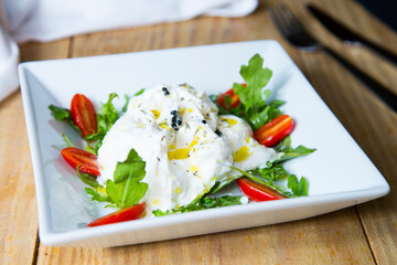 Burrata salad. The burrata is a fresh cow's milk cheese, with spun paste and round in shape, with an external appearance similar to that of mozzarella 