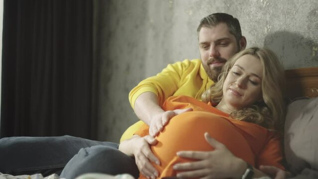 A man touches a pregnant woman's belly. A happy family is expecting a baby. The concept of love, grace and happiness together. High quality 4k footage
