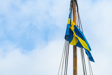 Swedish flag on sailing boat mast on windy summer day in Halmstad, Sweden