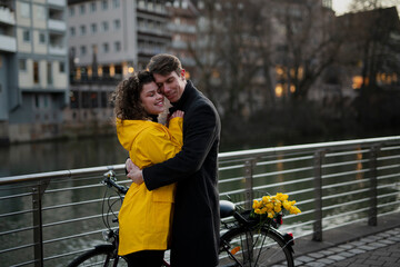 Fototapeta na wymiar Young in love couple on the bridge with a bicycle
