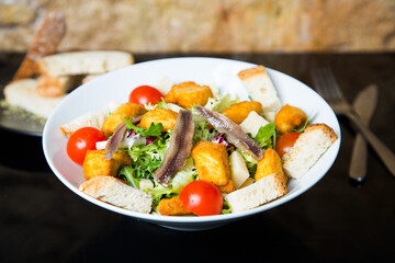 Delicious salad with anchovies and battered cheese.