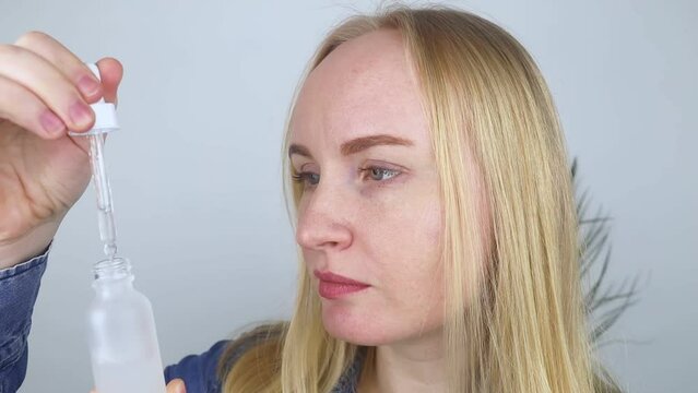 Niacinamide. Girl applies vitamin b3 to her face. Laboratory research. Skincare. Dermatological serum. Emulsion for narrowing of pores, normalization of sebum production and lightening of pigmentation