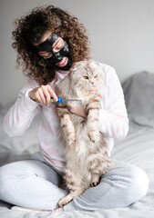 woman brushing British cat at home
