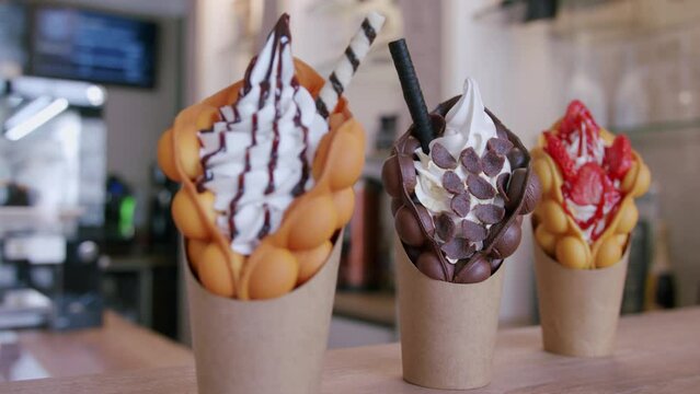chocolate and strawberry bubble waffles are presented on a counter
