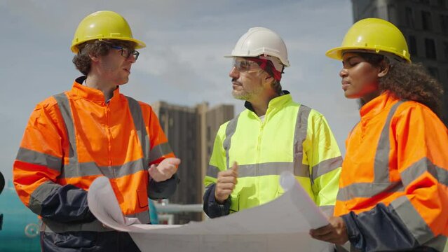 Structural engineer and architect meeting and working with blueprints to discuss at the outdoors construction site.Team building construction engineering and Senior foreman are talking the project