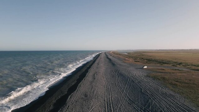 Empty, endless beach at golden hour; aerial establishing shot