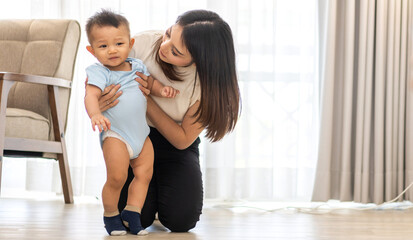 Portrait of enjoy happy love family asian mother playing with adorable little asian baby.Mom touching with cute son moments good time in room.Love of family concept