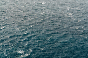 Naklejka na ściany i meble The surface of the blue sea from above. Endless sea. Waves.