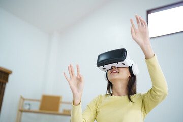 Young Asian woman wearing virtual reality touching air during the VR experience  Future technology concept.