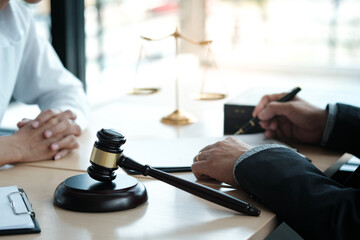 Legal counsel presents to the client a signed contract with gavel and legal law. justice and lawyer concept.