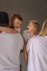 Family photo session in the studio. Happy family of four: mom, dad, son and daughter. 