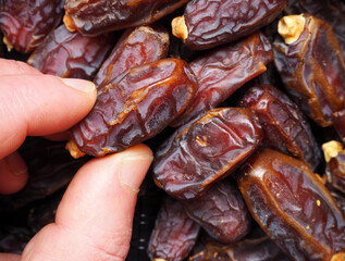 Handful of dried dates. Close up of dried dates. Sacred food of Ramadan for Muslims.