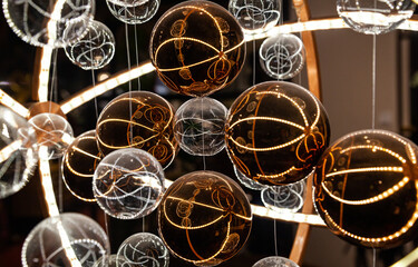 Glass translucent spheres on pendants in white and brown colors in a futuristic style close-up.