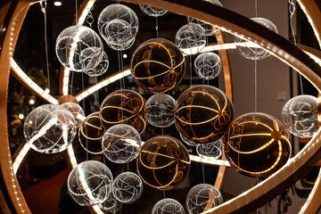 Glass translucent spheres on pendants in white and brown colors in a futuristic style close-up.