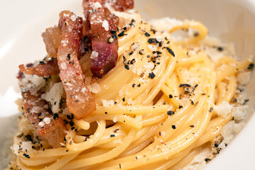 Piatto di deliziosi tipici spaghetti alla carbonara, ricetta tradizionale della cucina romana, cibo italiano 
