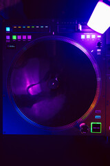 Close up of DJ mixing console in party light