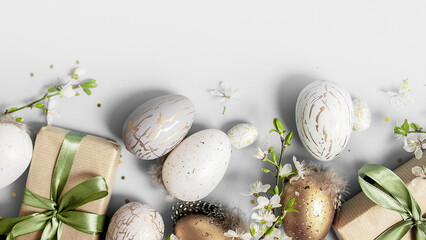 beautiful light easter layout with eco-wrapped gifts, golden and marble eggs, cherry blossoms and confetti on a white background. top view. copy space. flat lay. place for text