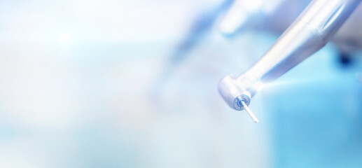 Closeup photo of dental handpieces and equipment on dental chair with blured background.