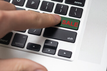 The finger pressing the sell button on the computer keyboard, believing bitcoin has changed the trend will sell.