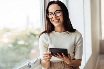 Happy female professional holding a tablet in an office