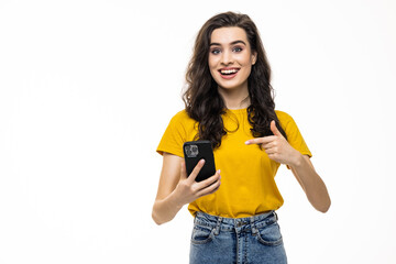 Young brunette woman smiling while using phone isolated over white background