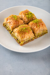 Pistachio Turkish baklava on a white plate.Close-up of four slices of baklava
