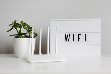 wifi connection concept - white router on table with plant