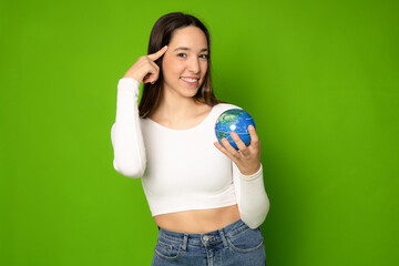Geography concept. Caucasian young woman eco-activist hugging embracing Earth globe with care, protecting planet from contamination, garbage, traveling abroad isolated in green background