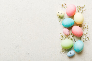 Happy Easter composition. Easter eggs on colored table with gypsophila. Natural dyed colorful eggs background top view with copy space